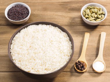 Kahverengi seramik kasede uzun tahıllı Basmati pilavı, tüm baharatlar, yeşil c