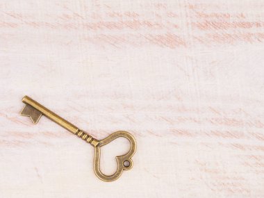 Kahverengi ahşap arka planda eski bronz anahtar.