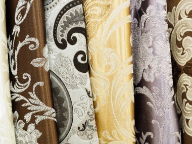 Bir dükkanda satılık sarı ve kahverengi kumaş. Moda kıyafetleri ve iç mekan kavramı.