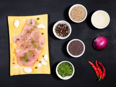 Tahta kesim tahtası, sarımsak, kimyon, tuz, rezene, baharat, hardal tohumu, yağ, kırmızı soğan, siyah ahşap zeminde kırmızı biber. Sağlıklı yeme kavramı