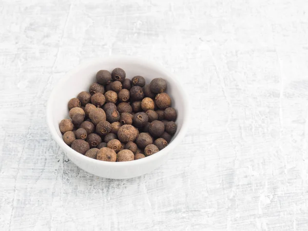 Specerij Allspice Peper Witte Keramische Kom Een Witte Betonnen Achtergrond — Stockfoto