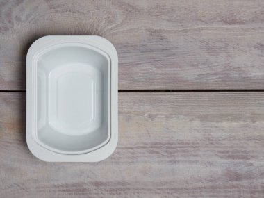 Beyaz kahverengi ahşap arka planda plastik beyaz bir banka.