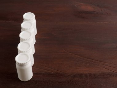 Kahverengi ahşap kapaklı beş küçük plastik banka.