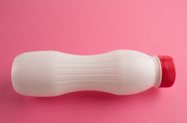 Pembe arka planda plastik beyaz şişe