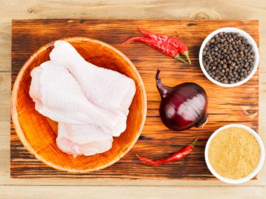 Bambu kasesi baharatında çiğ tavuk budu: kırmızı biber, masala, karabiber, kırmızı soğan. Sağlıklı yeme kavramı