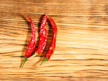 Üç kapsül, ahşap zemin üzerinde kırmızı biber ve fotokopi alanı. Sağlıklı yeme kavramı