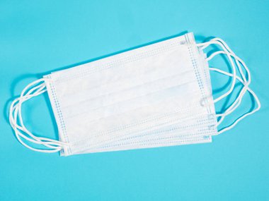 Mavi arka plandaki virüslere karşı korunmak için birkaç yüz maskesi. Fiziksel sağlık kavramı