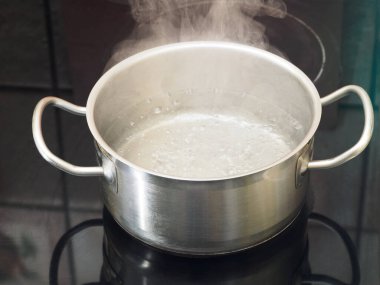 Fırında kaynar su olan paslanmaz çelik tava. Yemek pişirme konsepti