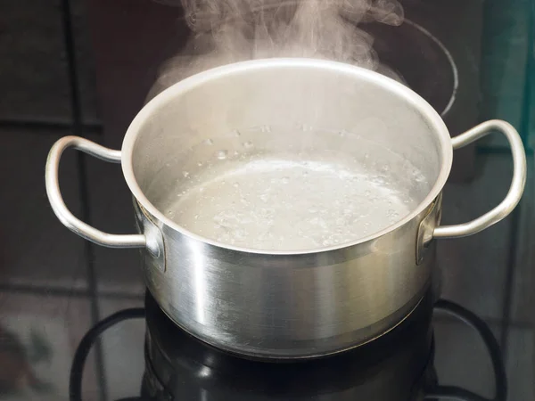 Fırında kaynar su olan paslanmaz çelik tava. Yemek pişirme konsepti