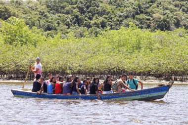 Bahia, Brezilya 'daki Caraiva Nehri' nde insanlar kayığa biniyor.