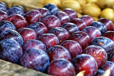 Çarşıda masada olgun sulu kırmızı erikler 