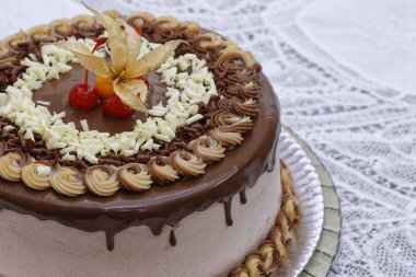 Meyvelerle süslenmiş çikolatalı kapuçino katmanlı pastayı kapat.