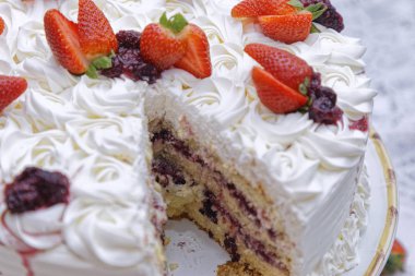 Krem şantili ve beyaz tabakta çilekli taze mascarpone keki.