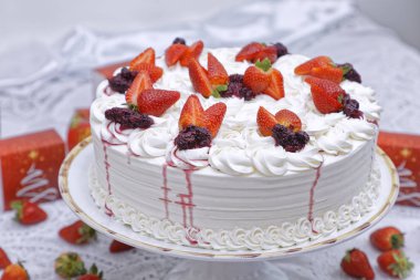 Çilekli taze çilekli pasta ve mutfak masasında krema.