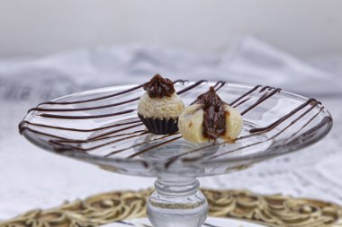 Küçük beyaz şekerler içinde çikolata ganache olan cam tabakta