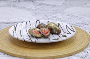 Süt çikolatası kaplı çilekler beyaz tabakta