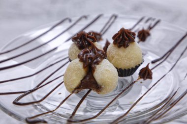 Beyaz hindistan cevizi şekeri ve içinde sıvı çikolata olan cam tabaklar.