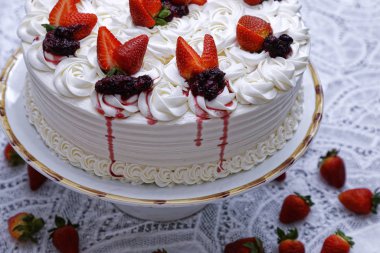 whipped cream cake with strawberries and jam on white plate