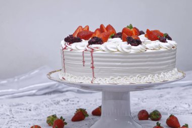 whipped cream cake with strawberries and jam on white plate