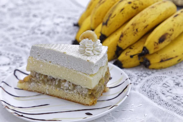 一层白色奶油香蕉蛋糕片 背景为香蕉 — 图库照片