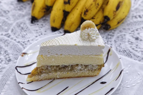 layer white buttercream banana cake slice with bananas on background