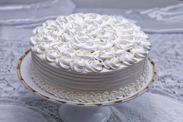 white cake with whipped cream on kitchen table