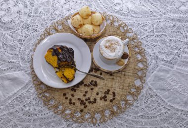 Bir parça ev yapımı limonlu kek, çikolatalı kahve, latte ve kahve çekirdekli peynirli çörekler. 