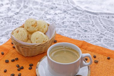 Mutfak masasının arkasında peynirli çöreklerle bir fincan sıcak kahve.