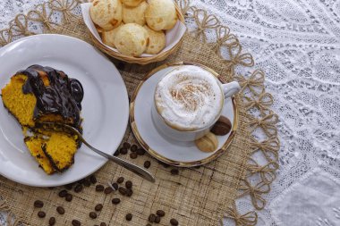 Bir parça ev yapımı limonlu kek, çikolatalı kahve, latte ve kahve çekirdekli peynirli çörekler. 