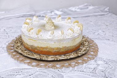 Beyaz arka planda krem şantili muzlu pasta.