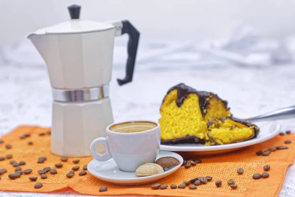 piece of homemade lemon cake with cup of coffee with coffee kettle on kitchen table background