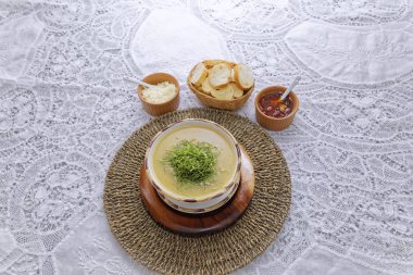 Sebze kremalı çorba, beyaz ekmek dilimleri, hasır sepette sos. 