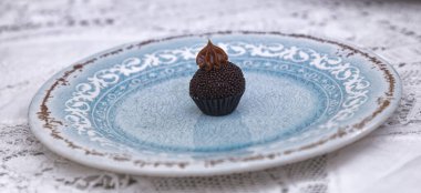 Yuvarlak çikolatalı şekeri mavi tabakta yakın. 