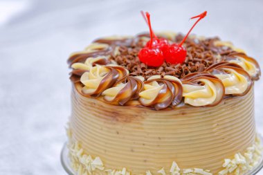 Beyaz pastayı, beyaz ve kahverengi tereyağlı ve kirazlı kaplayın. 