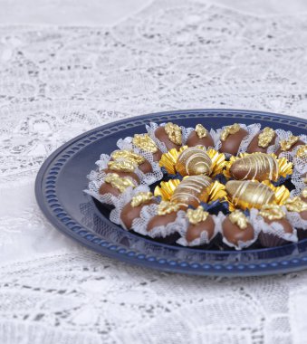 Mutfak masasında mavi tabakta lezzetli çikolata şekerlemeleri