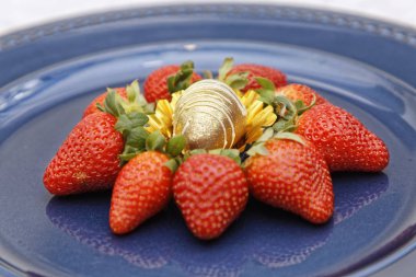 Mavi tabakta beyaz jöleli oval çikolata şekerli çilekler