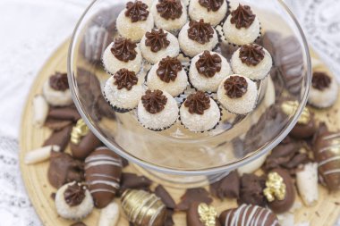 Mutfak masasının arkasında hindistan cevizli pralin ve çikolata şekeri var.