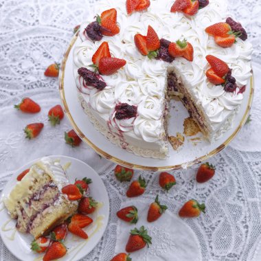 Krem şantili beyaz pasta ve beyaz tabakta reçelli çilek.