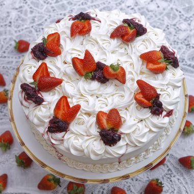 Krem şantili mascarpone keki ve beyaz tabakta çilek.