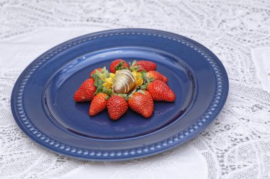 Mavi tabakta çikolata şekerli çilekler