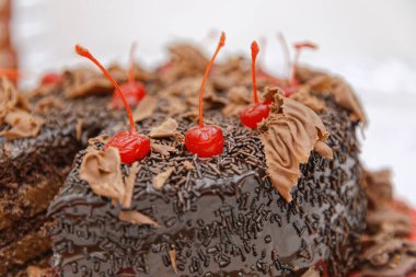 Çikolata jöleli ve kirazla süslenmiş çikolatalı pastayı kapat. 