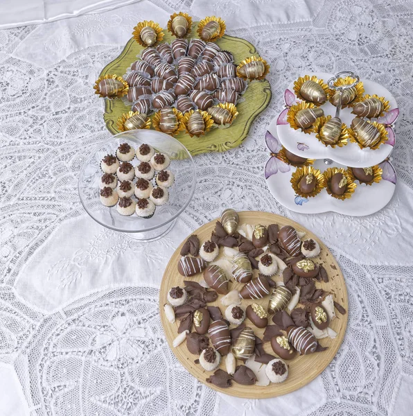different delicious chocolate candies on kitchen table background