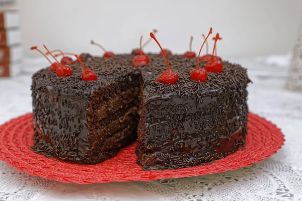 红盘上装饰有樱桃的巧克力奶油黑巧克力蛋糕 — 图库照片