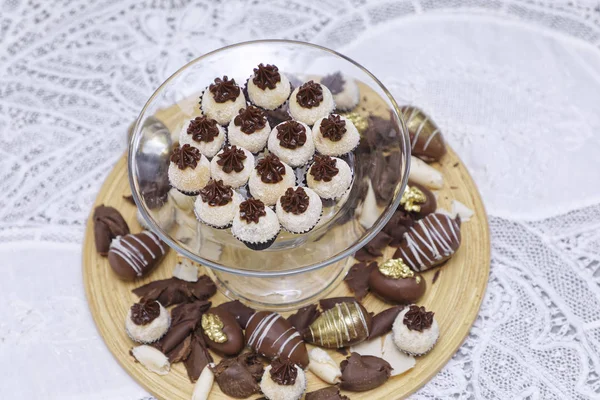 lots of tasty chocolate candies on kitchen table background