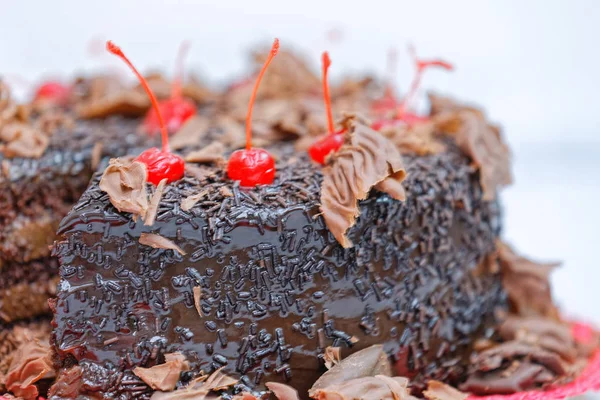 チョコレートバタークリームとチェリーで飾られたチョコレートケーキの終わり — ストック写真