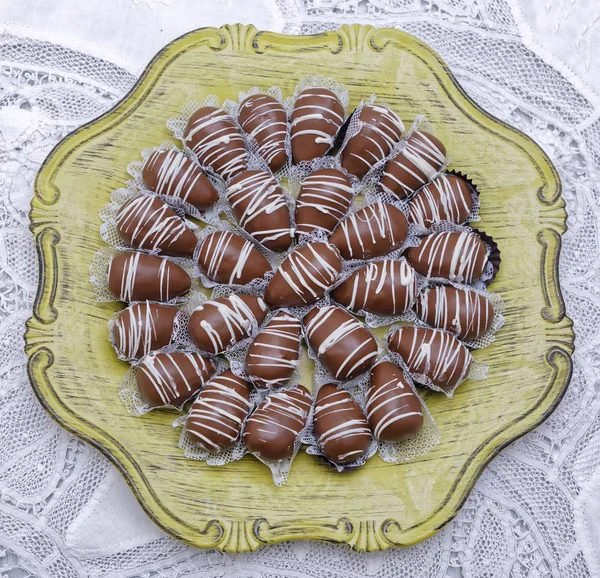 Dark Chocolate Candies White Glaze Green Plate Kitchen Table Background — Stock Photo, Image