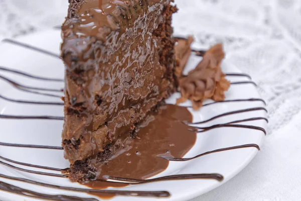 ホワイトプレートにチョコレート釉薬をかけた焼きたてのチョコレートケーキのスライス — ストック写真