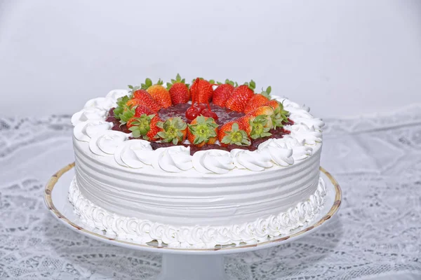 白いキッチンテーブルの上にホイップクリームとイチゴの白いケーキ背景 — ストック写真