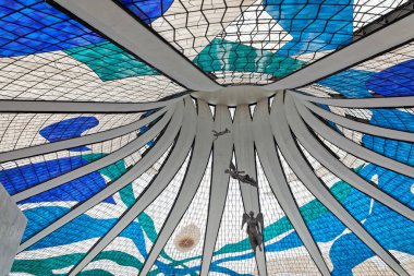 big colored stained glass windows with statues of angels on ceiling in Metropolitan Cathedral of Nossa Senhora Aparecida in Brasilia, Brazil clipart