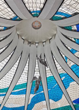 beautiful angel statues hanging from the ceiling with stained glass windows in Metropolitan Cathedral of Nossa Senhora Aparecida in Brasilia, Brazil